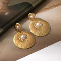 Stainless Steel Aura Signature Textured Gold Drop Earrings Featuring Sunburst Disc Design With Pearl Accents